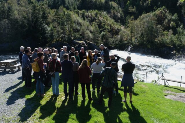 «Laksekongen» i Suldal, Bjørn Moe informerer om villaksens ve og vel i Suldalslågen. Sandsfossen i bakgrunnen. 